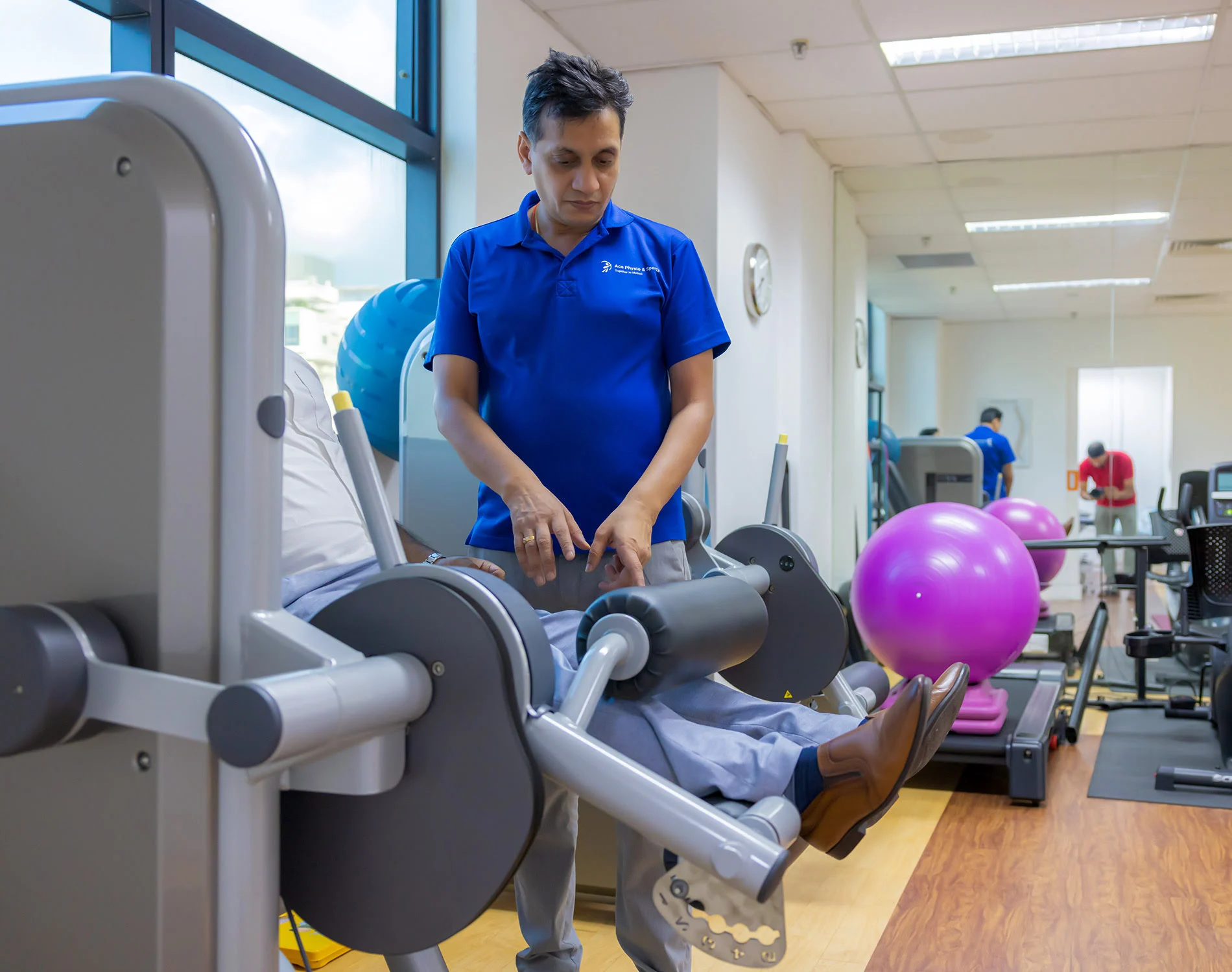 Dr. Vineet Bansal conducting physiotherapy treatment session with patient at Ace Physio Sports Singapore